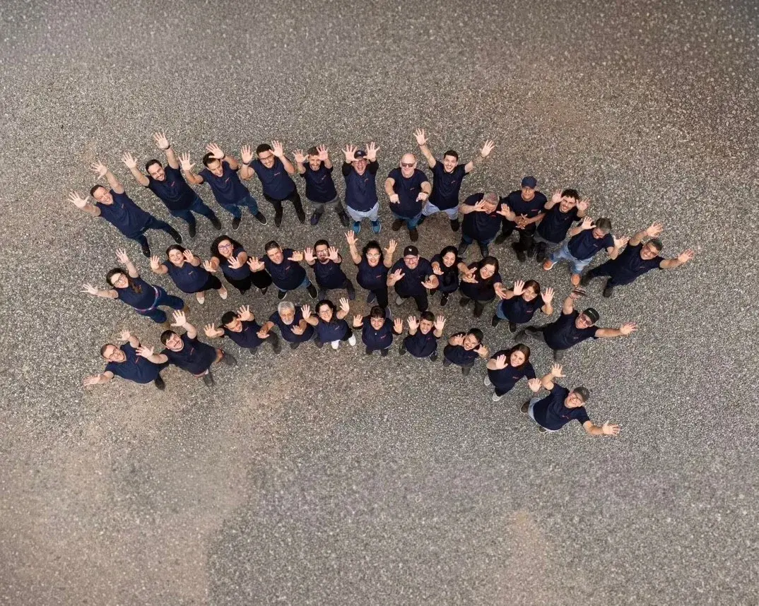 Equipe da Máxima Gráfica reunida no pátio da fábrica