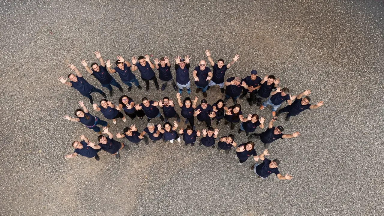 Equipe da Máxima Gráfica reunida no pátio da fábrica